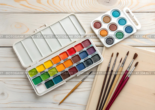 Watercolor paints and brushes arranged on a wooden table ready for an artistic project at a creative workspace during the afternoon. Стоковое AI-изображение, AI-художник Анна Сивакова / Фотобанк Лори