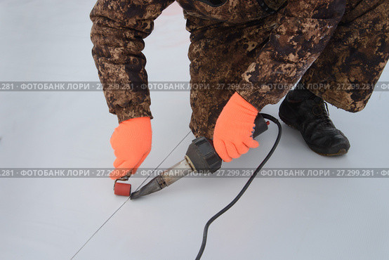 Waterproofing and insulation at construction site, roof sealing process of synthetic membrane with Hot Air Hand Tool. New protection technology. Closeup. Стоковое фото, фотограф Сергей Дорошенко / Фотобанк Лори