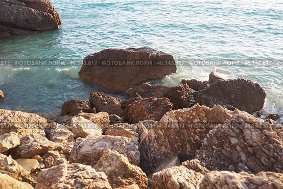 Waves gently crash against the rugged rocks while the sun sets over the horizon. Experience the serene beauty of this coastal location filled with natural wonders. Canj, Montenegro, Adriatic sea (2024 год). Стоковое фото, фотограф Юлия Петровская / Фотобанк Лори