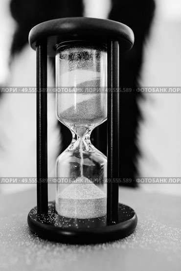 white sand hourglass in brown wood on table. Стоковое фото, агентство Ingram Publishing / Фотобанк Лори
