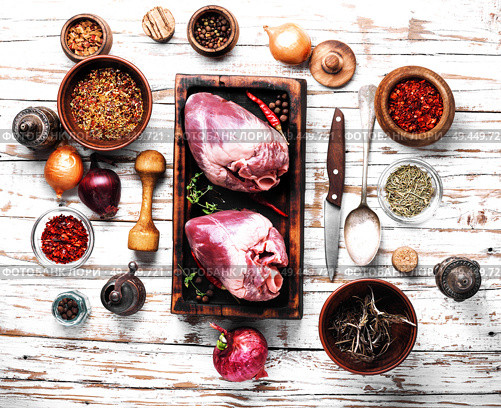 Whole pork heart on a chopping board. Raw pork heart. Стоковое фото, агентство Ingram Publishing / Фотобанк Лори