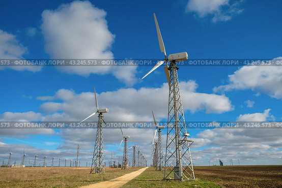 Wind turbines in a field under cloudy sky, generating electricity. Стоковое фото, фотограф Тереза Шахназарян / Фотобанк Лори