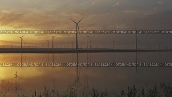 Windmills turbines with sunrise reflection. Стоковое видео, видеограф Михаил Коханчиков / Фотобанк Лори