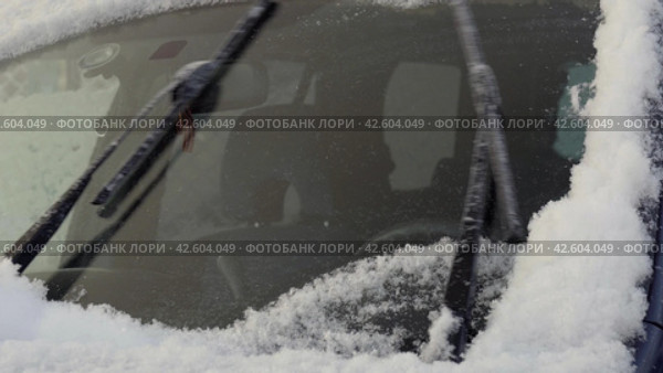 Windscreen Wipers brushing away the snow from a car's windshield. Стоковое видео, видеограф EStarodubov / Фотобанк Лори