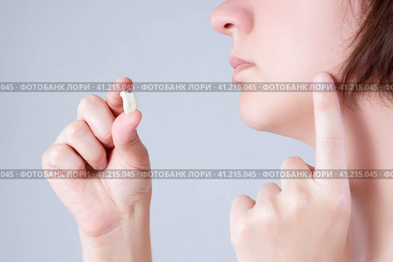 Wisdom tooth extraction, woman suffering from a toothache on gray background. Стоковое фото, фотограф Станислав Тарко / Фотобанк Лори