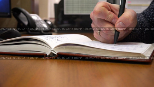 With a black pen, a young man writes in his notebook. Стоковое видео, видеограф Aleksandr Sulimov / Фотобанк Лори