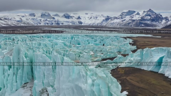 Witness breathtaking ice formations juxtaposed against majestic mountains in a winter landscape. Стоковое AI-видео, аниматор Данила Большаков / Фотобанк Лори