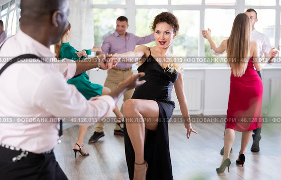 Woman dances incendiary boogie woogie with African man partner during choreography lesson. Стоковое фото, фотограф Яков Филимонов / Фотобанк Лори