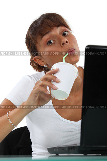 Woman drinking soft drink at desk. Стоковое фото, агентство Ingram Publishing / Фотобанк Лори