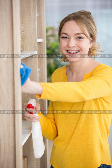woman dusting the home with a smile. Стоковое фото, агентство Ingram Publishing / Фотобанк Лори