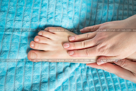 Woman giving herself foot massage, corns and calluses on feet, dry skin on legs. Стоковое фото, фотограф Станислав Тарко / Фотобанк Лори