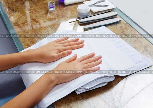 woman hands with nails before treatment on white towel in salon. Стоковое фото, агентство Ingram Publishing / Фотобанк Лори