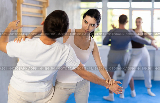 Woman hits man attacker on head during self-defense training session led by trainer. Стоковое фото, фотограф Яков Филимонов / Фотобанк Лори