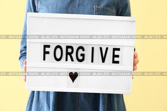 Woman holding board with word FORGIVE on color background, closeup. Стоковое фото, фотограф Pixel_shot / Фотобанк Лори