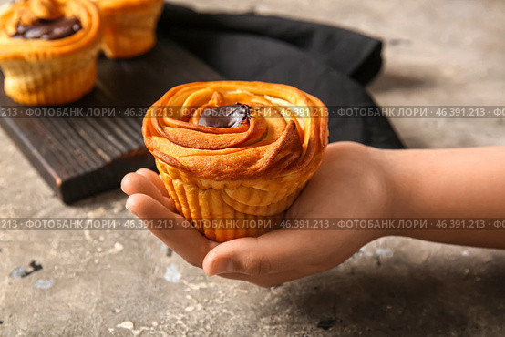 Woman holding tasty cruffin with chocolate on grey background. Стоковое фото, фотограф Pixel_shot / Фотобанк Лори