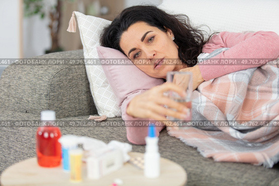 woman ill on sofa with various medication. Стоковое фото, агентство Ingram Publishing / Фотобанк Лори