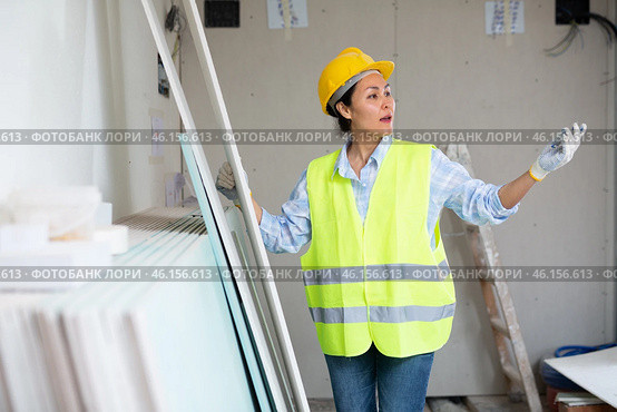 Woman in hardhat and vest counting drywall sheets. Стоковое фото, фотограф Яков Филимонов / Фотобанк Лори