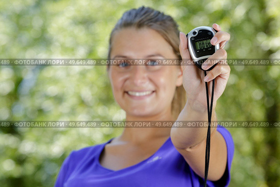 woman in sports showing a chronometer. Стоковое фото, агентство Ingram Publishing / Фотобанк Лори