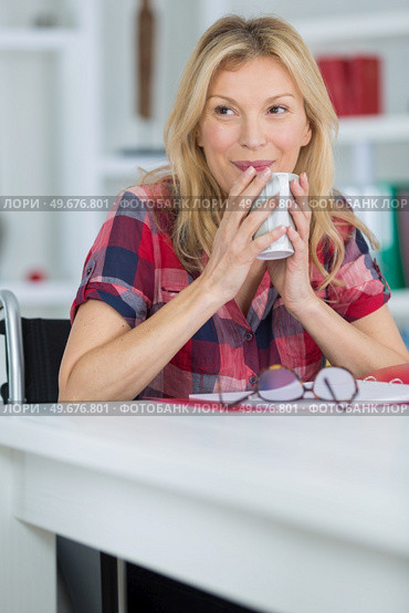 woman in wheelchair hot drink at home. Стоковое фото, агентство Ingram Publishing / Фотобанк Лори