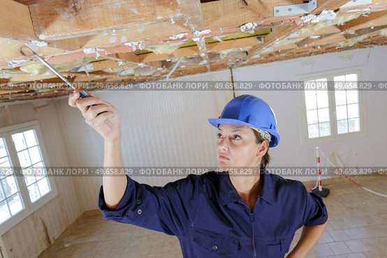 woman inspecting wooden timbers on renovation site. Стоковое фото, агентство Ingram Publishing / Фотобанк Лори