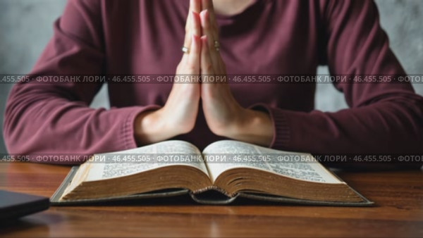 Woman is praying while holding a book open in front of her. Стоковое AI-видео, аниматор Sergey Grishin / Фотобанк Лори