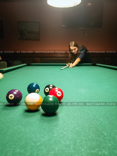 Woman leaning over the table while playing billiard. Стоковое фото, фотограф Константин Григорьев / Фотобанк Лори