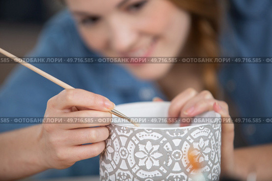 woman making pattern on ceramic vase. Стоковое фото, агентство Ingram Publishing / Фотобанк Лори