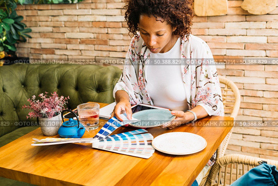 woman matching color swatch with plate table. Стоковое фото, агентство Ingram Publishing / Фотобанк Лори