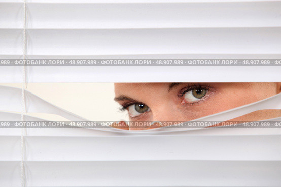 Woman peering through blinds. Стоковое фото, агентство Ingram Publishing / Фотобанк Лори