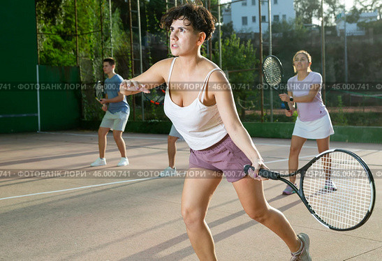 Woman playing frontenis with partners at sunny day, healthy lifestyle concept. Стоковое фото, фотограф Яков Филимонов / Фотобанк Лори