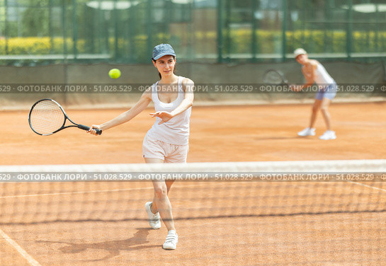 Woman playing tennis against female opponent on tennis court. Стоковое фото, фотограф Яков Филимонов / Фотобанк Лори