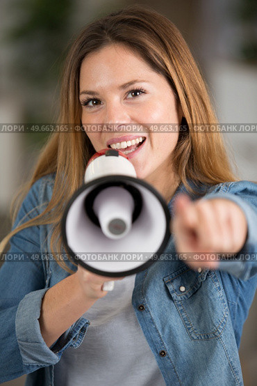 woman pointing forwards while speaking through megaphone. Стоковое фото, агентство Ingram Publishing / Фотобанк Лори