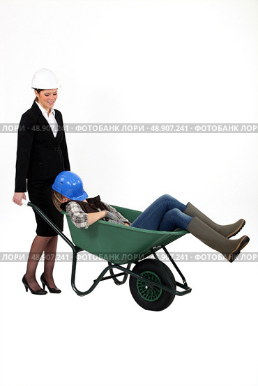 Woman pushing sleepy colleague in a wheelbarrow. Стоковое фото, агентство Ingram Publishing / Фотобанк Лори