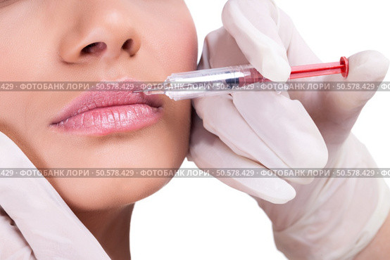 woman receiving a botox injection in her lips, close up . Стоковое фото, агентство Ingram Publishing / Фотобанк Лори