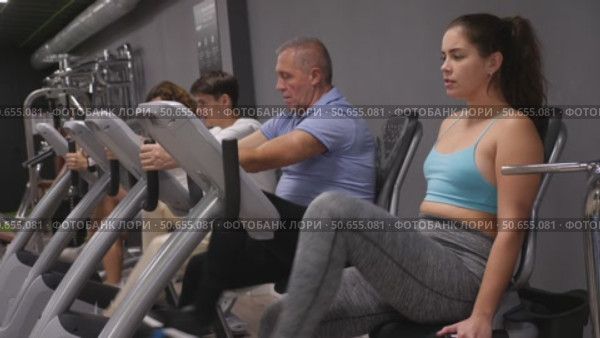 Woman riding cardiovascular trainers in modern gym. Стоковое видео, видеограф Яков Филимонов / Фотобанк Лори