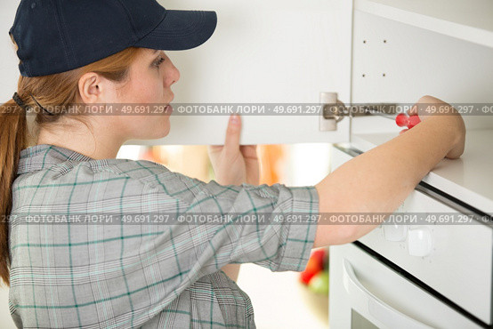 woman screws the side of the door. Стоковое фото, агентство Ingram Publishing / Фотобанк Лори