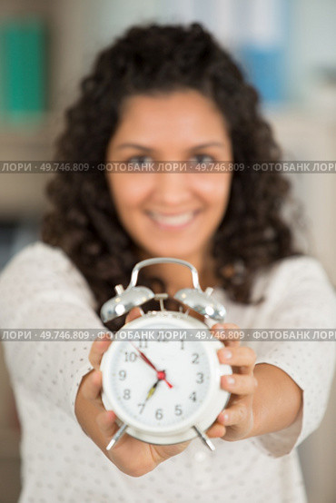 woman showing the time on an alarm clock. Стоковое фото, агентство Ingram Publishing / Фотобанк Лори