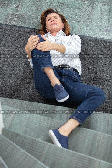 woman slipped down stairs has sustained a knee injury. Стоковое фото, агентство Ingram Publishing / Фотобанк Лори