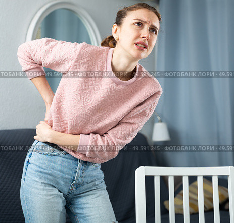 Woman suffering from lower back pain at home. Стоковое фото, фотограф Яков Филимонов / Фотобанк Лори
