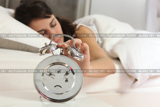 Woman turning off alarm clock. Стоковое фото, агентство Ingram Publishing / Фотобанк Лори