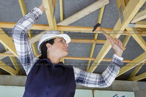 woman uses a hammer to fix structure. Стоковое фото, агентство Ingram Publishing / Фотобанк Лори