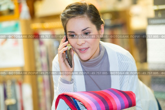 woman using the phone in a textile store. Стоковое фото, агентство Ingram Publishing / Фотобанк Лори