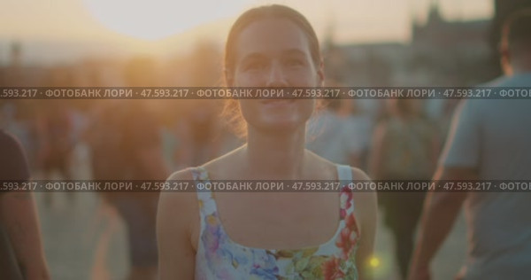 Woman walks through the crowded streets of Prague at sunset, blending into the vibrant atmosphere of the historic city. Стоковое видео, видеограф Igor Tichonow / Фотобанк Лори