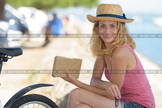 woman wearing a hat relaxing while reading a book. Стоковое фото, агентство Ingram Publishing / Фотобанк Лори