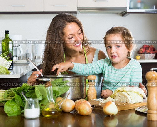 Woman with baby cooking at kitchen. Стоковое фото, фотограф Яков Филимонов / Фотобанк Лори