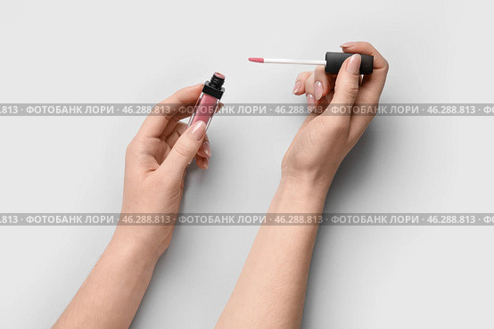 Woman with lipgloss on light background. Стоковое фото, фотограф Pixel_shot / Фотобанк Лори