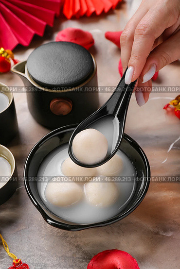 Woman with spoon and bowl of tangyuan on grunge background, closeup. Dongzhi Festival. Стоковое фото, фотограф Pixel_shot / Фотобанк Лори