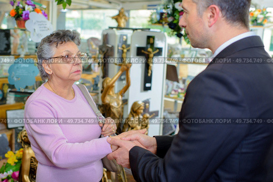 Woman with undertaker amongst memorial artefacts. Стоковое фото, агентство Ingram Publishing / Фотобанк Лори