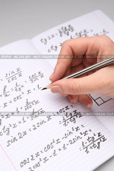 Woman writing maths formulas in copybook with pencil, closeup. Стоковое фото, фотограф Pixel_shot / Фотобанк Лори