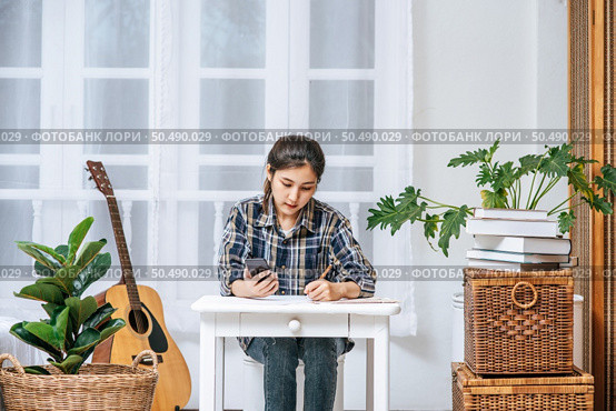Women sit at the desk and use the phone to coordinate. Стоковое фото, агентство Ingram Publishing / Фотобанк Лори